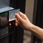 A person swiping a keycard through a card access control systems for secure entry.