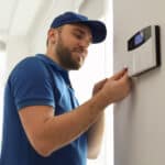 A professional technician in access control installations system on a wall, ensuring secure and reliable entry management.