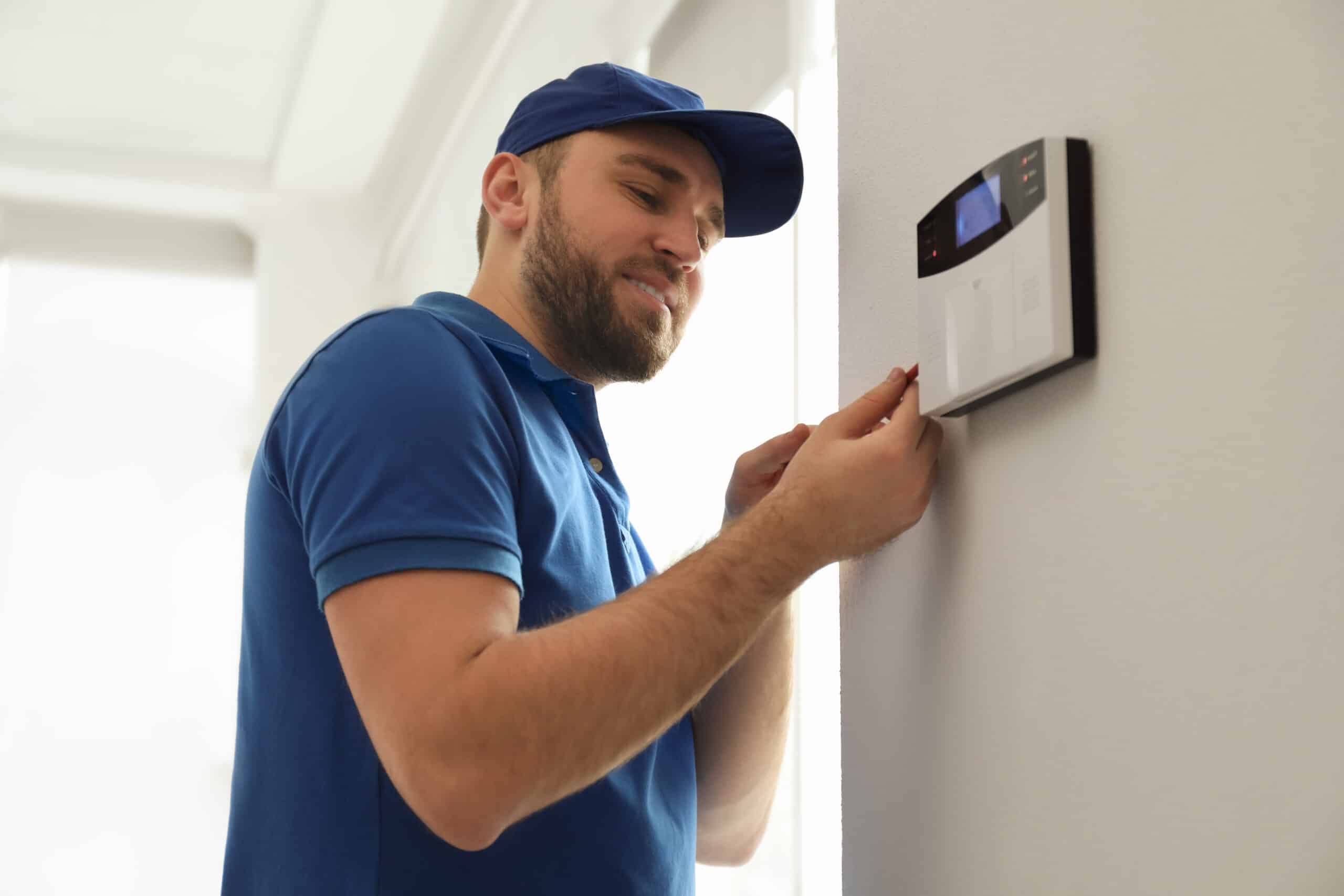 A professional technician in access control installations system on a wall, ensuring secure and reliable entry management.